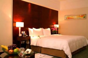 a hotel room with a bed and a bowl of fruit on a table at Sheraton Ningbo Hotel - Tianyi Square in Ningbo