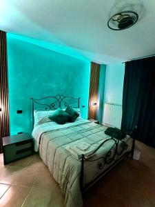 una camera con un letto con una parete blu di La balena bianca house a Bagni San Filippo