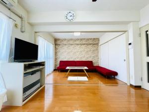 uma sala de estar com um sofá vermelho e uma mesa em 中島9-1　NEW OPEN　景観最良の1LDK50㎡の室内空間　地下鉄駅徒歩5分以内 em Toyohira