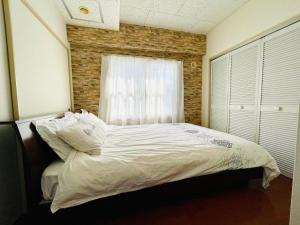 uma cama num quarto com uma parede de tijolos em 中島9-1　NEW OPEN　景観最良の1LDK50㎡の室内空間　地下鉄駅徒歩5分以内 em Toyohira