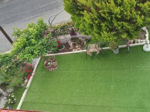 an overhead view of a green yard with benches and flowers at NIKI STAVROS COMFORT STUDIOS in Stavros