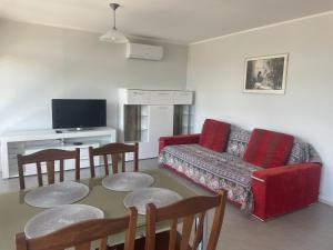 a living room with a couch and a table and chairs at Apartma pri Cesarjevih in Sežana