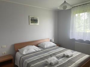 a bedroom with a bed with two towels on it at Apartma pri Cesarjevih in Sežana