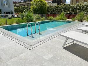 een klein zwembad met een tafel en een bank bij Villa Fedora Luxury Suites in Lucca