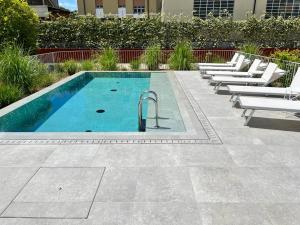 a swimming pool with white lounge chairs next to a building at Villa Fedora Luxury Suites in Lucca