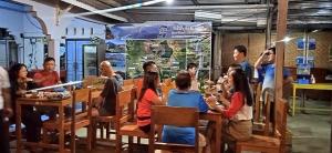 a group of people sitting at tables in a restaurant at Anak Rinjani Guest House in Senaru