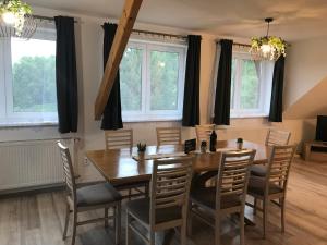a dining room with a wooden table and chairs at Riverside Habovka in Habovka