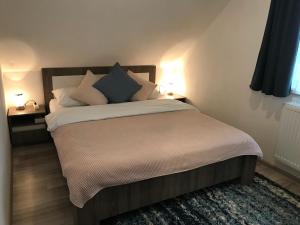 sypialnia z łóżkiem z poduszkami i 2 lampami w obiekcie Riverside Habovka w Habówce