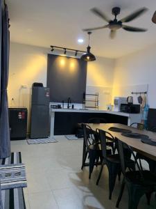 a room with tables and a kitchen with a ceiling fan at rumahpantai.afr in Kuantan