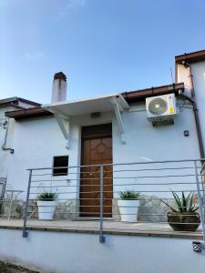una casa blanca con macetas en el porche delantero en CASINA DAMÍ en Canosa Sannita