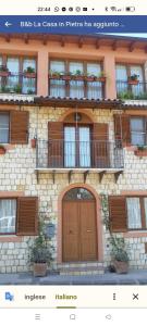 ein Gebäude mit einer Holztür und einem Balkon in der Unterkunft La Casa In Pietra in Santa Caterina Villarmosa