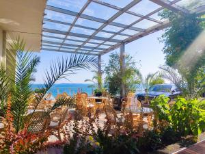 a patio with tables and chairs and a view of the ocean at Moonlight Hotel - All Inclusive in Sveti Vlas