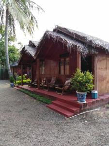 une petite maison avec des chaises et un toit de chaume dans l'établissement Blue Ocean Cabana, à Trincomalee