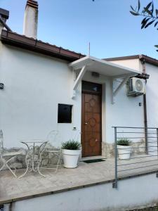 a white house with a table and a wooden door at CASINA DAMÍ in Canosa Sannita