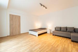 biały pokój z łóżkiem i kanapą w obiekcie Brand new two room apartment #64 in Elite Rezidence with free secure parking w Pradze