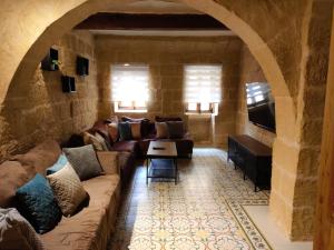 a living room with a couch and a tv at Ta' Frenc Farmhouse in Għarb