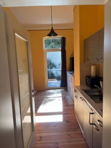 eine Küche mit gelben Wänden, Holzböden und einem Fenster in der Unterkunft Forsthaus Neudorf in Harzgerode