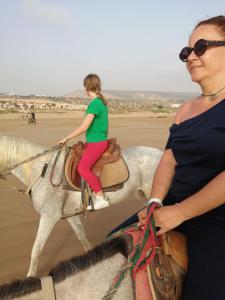 two women riding on horses on the beach at Agadir aourir maroc in Aourir
