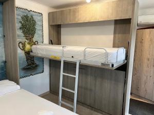 a bunk bed in a small room with a ladder at Sunshine Apartments in Mákri