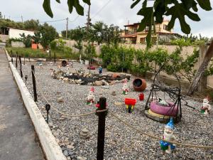 a garden with a fence with gnomes on the rocks at Sunshine Apartments in Mákri