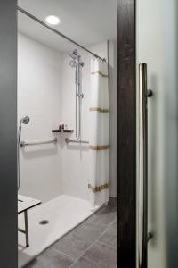 y baño con ducha y cortina de ducha. en Marriott Cincinnati Northeast, en Mason