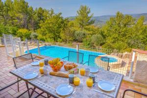 a table with food on it next to a swimming pool at Villa Colombes in Draguignan