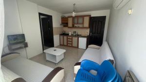 a living room with two white couches and a kitchen at Oğuz Apart in Side