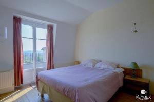 a bedroom with a large bed and a large window at L' Eglise - 2 pièces avec balcon au dernier étage vue Paris in Saint-Prix
