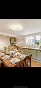 a large wooden table with chairs and a kitchen at Cosy Farm house in Forest of Dean in Westbury on Severn