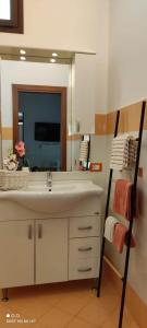 Un baño con lavabo y un espejo grande. en Elisir - Apartment, en Trapani 22 fotos más