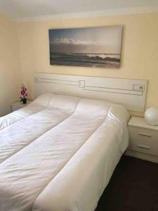 a bedroom with two beds and a painting on the wall at Casa Rural en CADAVEDO LUARCA ASTURIAS in Villademoros