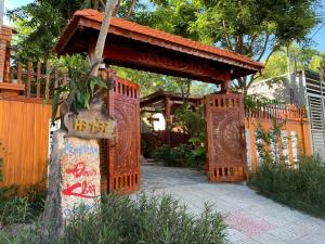 Tân Tạo的住宿－Đan Khôi Homestay Lagi，花园入口,带木门