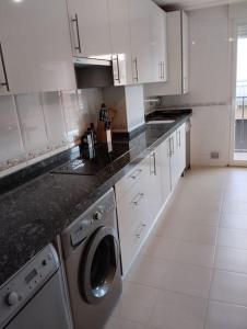 eine weiße Küche mit einer Waschmaschine und einem Geschirrspüler in der Unterkunft Alba de Tormes Salamanca Piso de 2 habitaciones 3 camas in Alba de Tormes