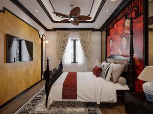 um quarto com uma cama grande e uma ventoinha de tecto em Monaco Hotel em Can Tho