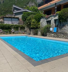 una piscina azul frente a una casa en Appartamento “La casetta di Mirto”, en Porlezza
