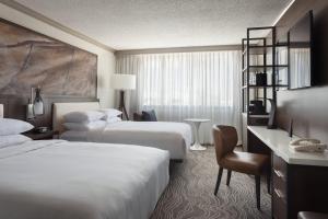 a hotel room with two beds and a desk at Marriott Tampa Westshore in Tampa