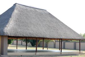 a thatched roof pavilion at a park at Elson Manor Guesthouse in Tzaneen