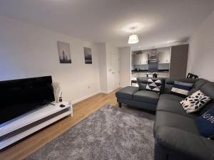 a living room with a couch and a flat screen tv at Modern 2 bed 2 bath Flat Close to Train station in Belvedere