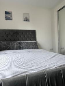a bedroom with a large bed with a black headboard at Modern 2 bed 2 bath Flat Close to Train station in Belvedere