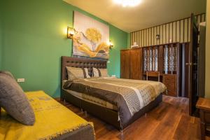 - une chambre avec un lit et des murs verts dans l'établissement Mana-An Lake Hill Resort Villa, à Chiang Mai