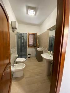 a bathroom with two sinks and a shower and two toilets at CASA SANT'ANNA in SantʼAnna Arresi