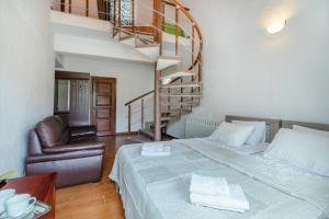 a bedroom with a bed and a spiral staircase at EcoRest - Likani Palace in Borjomi