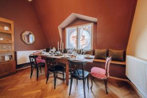 布拉格的住宿－Magnificent historical penthouse in the heart of Prague，一间带长桌和椅子的用餐室