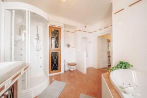 a white bathroom with a tub and a sink at Magnificent historical penthouse in the heart of Prague in Prague +36 photos