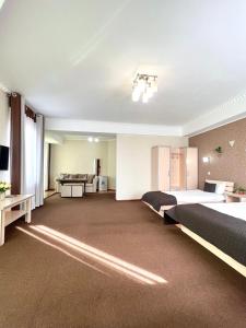 Habitación grande con 2 camas y sofá en Caravan Hotel, en Karakol