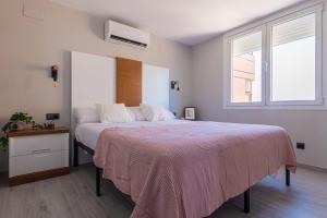 Un dormitorio con una cama grande con una manta rosa. en Torre 2 planta 11, en Fuengirola 34 fotos más