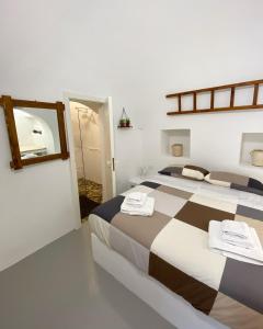 - une chambre avec 2 lits et un miroir dans l'établissement Trullo Le radici del Pino, à Martina Franca