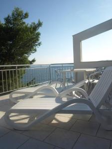 a group of chairs and tables on a balcony at Vila Dvorski in Baška Voda