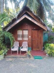 une petite cabine avec deux chaises et une porte dans l'établissement Blue Ocean Cabana, à Trincomalee