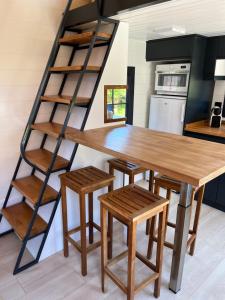 a kitchen with a wooden table and a ladder at Tiny House Piscine et Spa in Gaillac